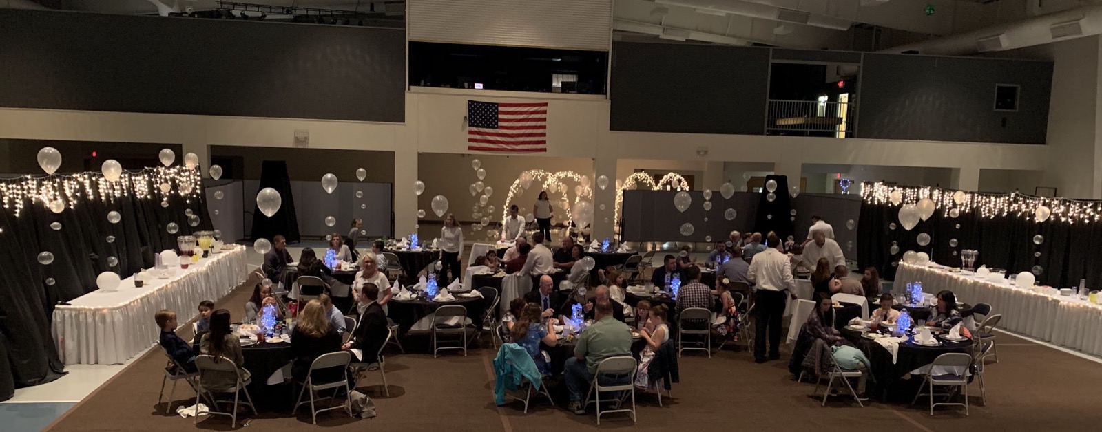 A dinner banquet with string lights and round tables