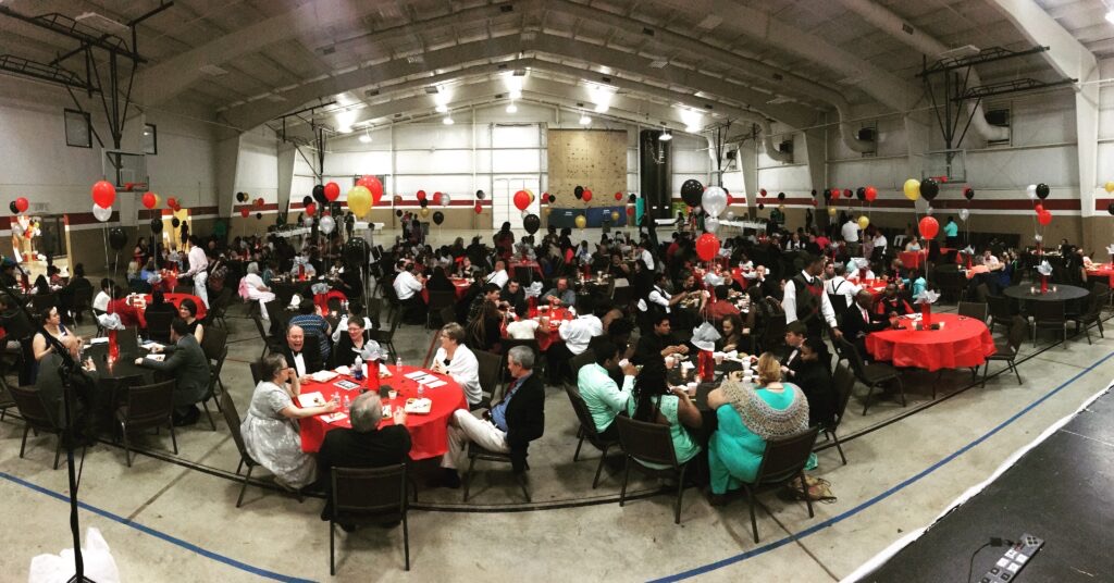A banquet hall full of guests at round tables