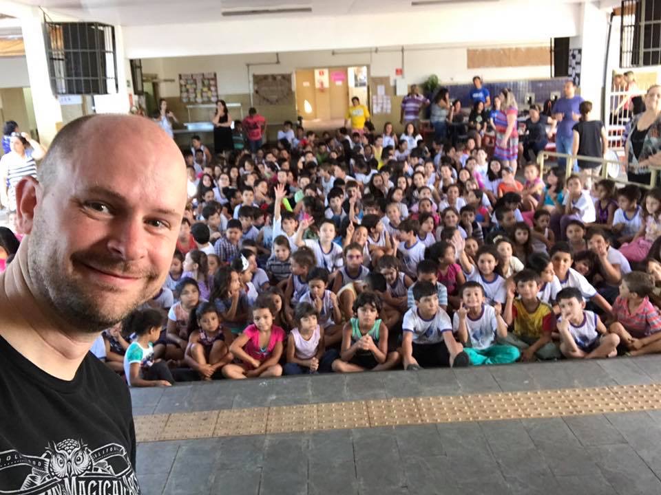 Matt Adams in front of a gym full of students