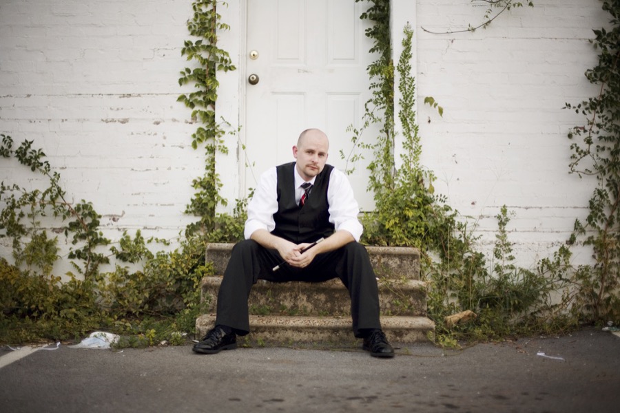 Matt Adams seated outdoors in a vest and tie